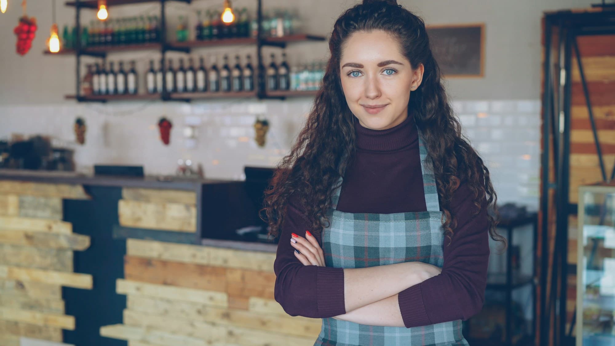 A café owner standing behind her counter